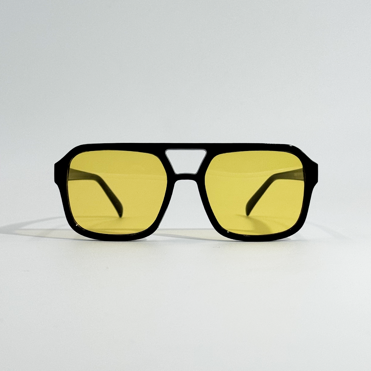 Amber pilot sunglasses with black polycarbonate frame and yellow lenses.