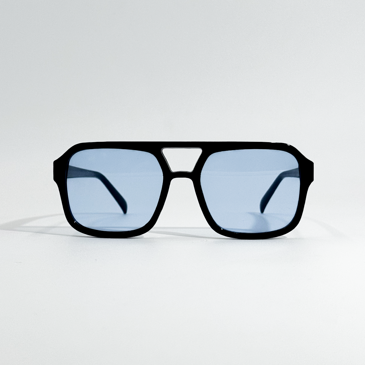 Arctic Noir retro sunglasses with black polycarbonate frame and light blue UV400 lenses.