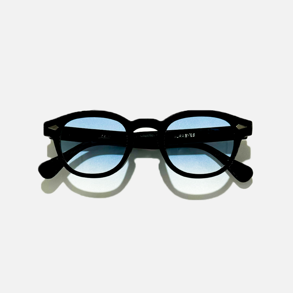 Azure Noir SS26 Circle Collection sunglasses with black frames and light blue UV 400 lenses.