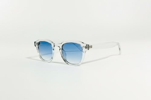 Blue Clarity transparent frame sunglasses with round blue gradient lenses.
