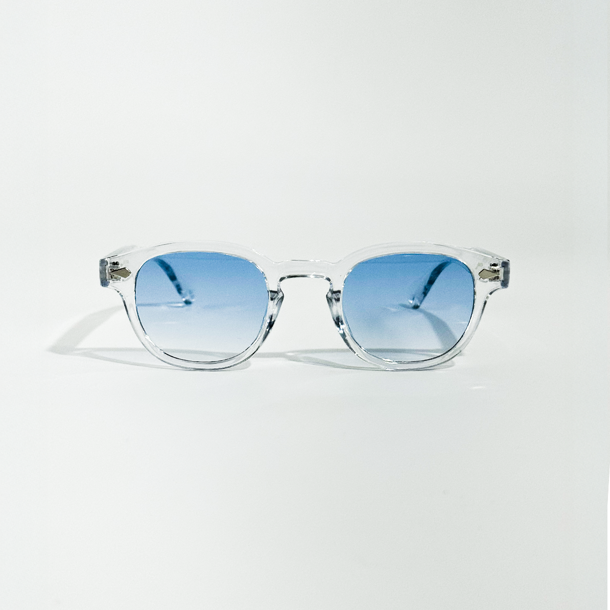 Blue Clarity transparent frame sunglasses with round blue gradient lenses.