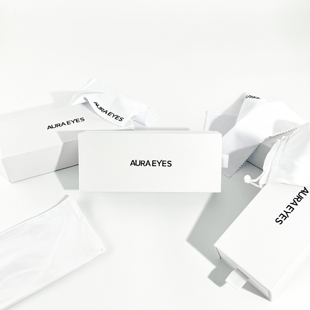 Aura Eyes white packaging boxes, soft pouches, and cleaning cloths on a white background.