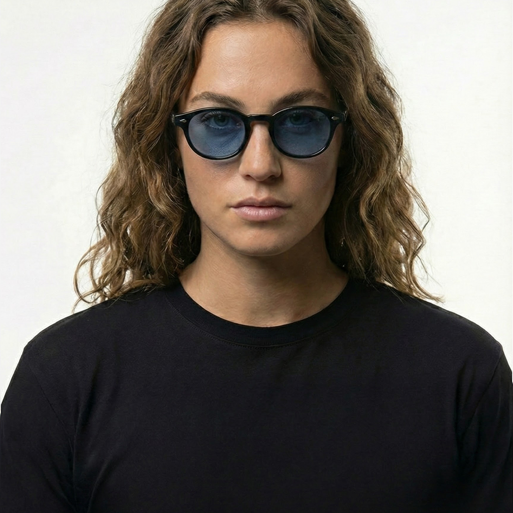 Person wearing black round sunglasses with blue lenses, black frame.