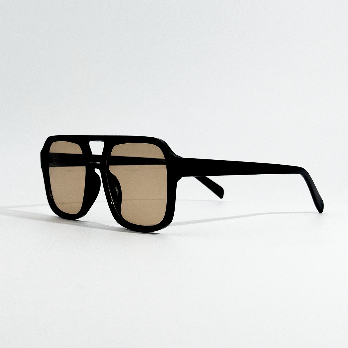 Golden Noir retro sunglasses with a black frame and gold lenses, angled on a white background.