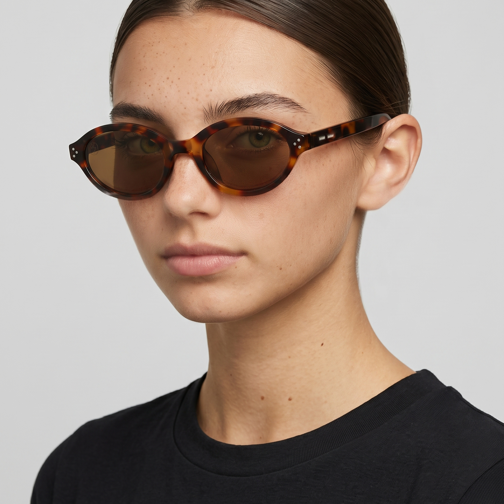 Woman wearing Havana Muse dark Havana brown oval sunglasses with polycarbonate lenses.