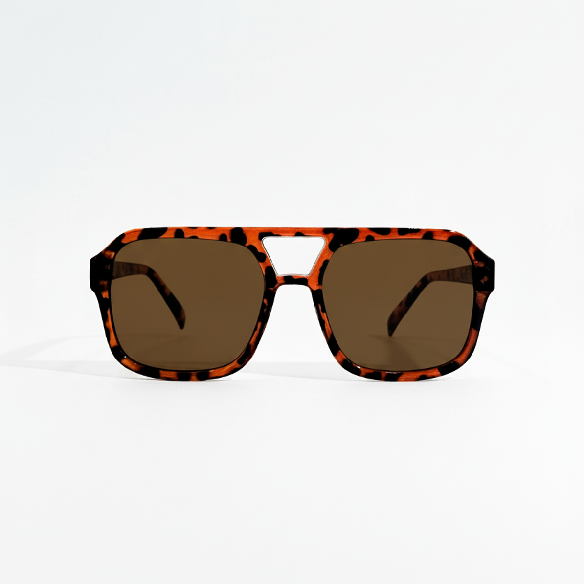 Havana pilot sunglasses with dark black lenses and a tortoiseshell frame on a white background.