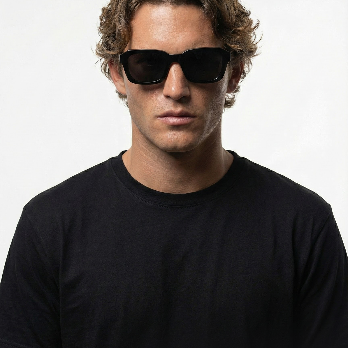Man wearing Midnight Noir black lens square sunglasses with a black t-shirt.